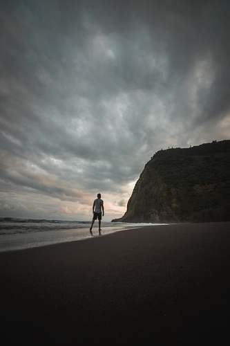 grey man standing shore waipio valley